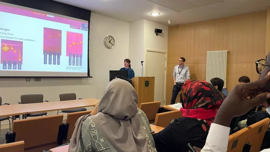Izzy and John present research data at a conference